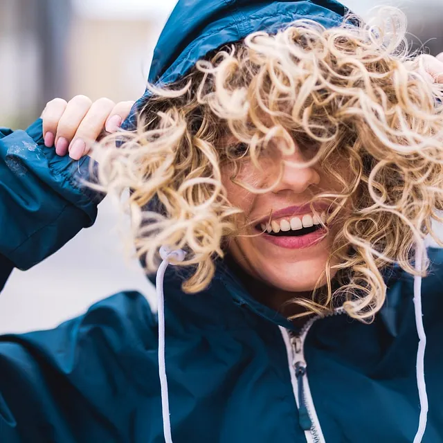 chica de pelo rizo con sudadera azul